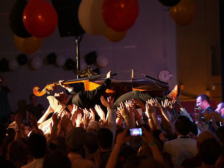 A double bass player crowd surfing